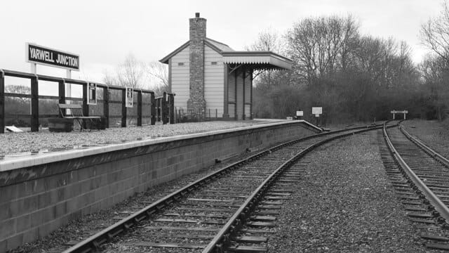 A black and white photo of the last stop on a train line.